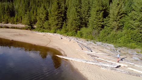 Frau-Mit-Ihrem-Hund-Geht-An-Einem-Sonnigen-Tag-In-Der-Nähe-Der-Flussküste-Spazieren-4k