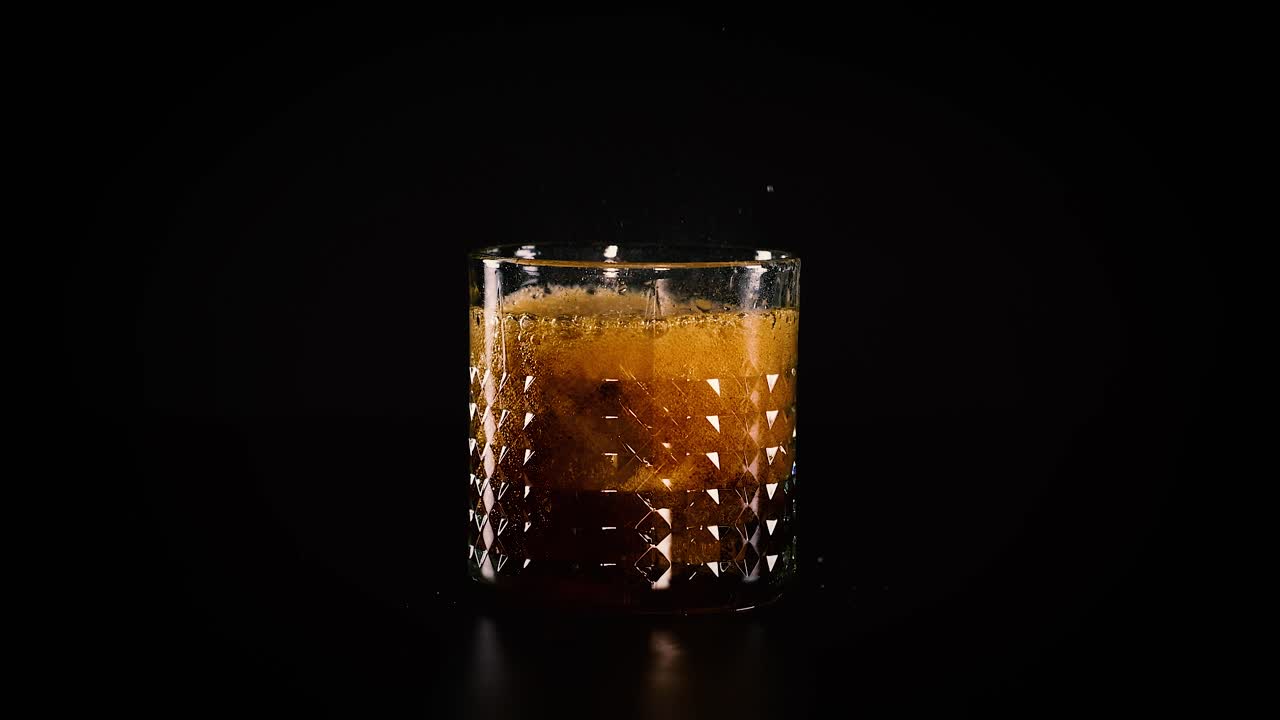 Cola sendo derramada em um copo com gelo