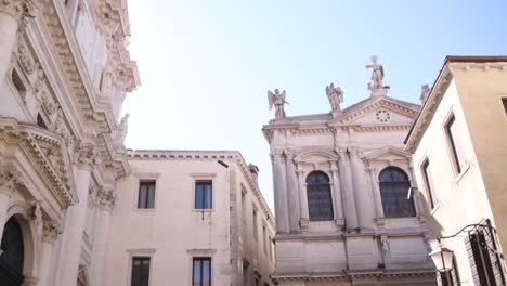 close-up view of venetian buildings with statues, ornate facades, and corinthian columns.