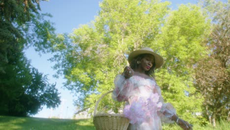 lack-Woman-walking-in-park-in-dress-with-basket-low-angle