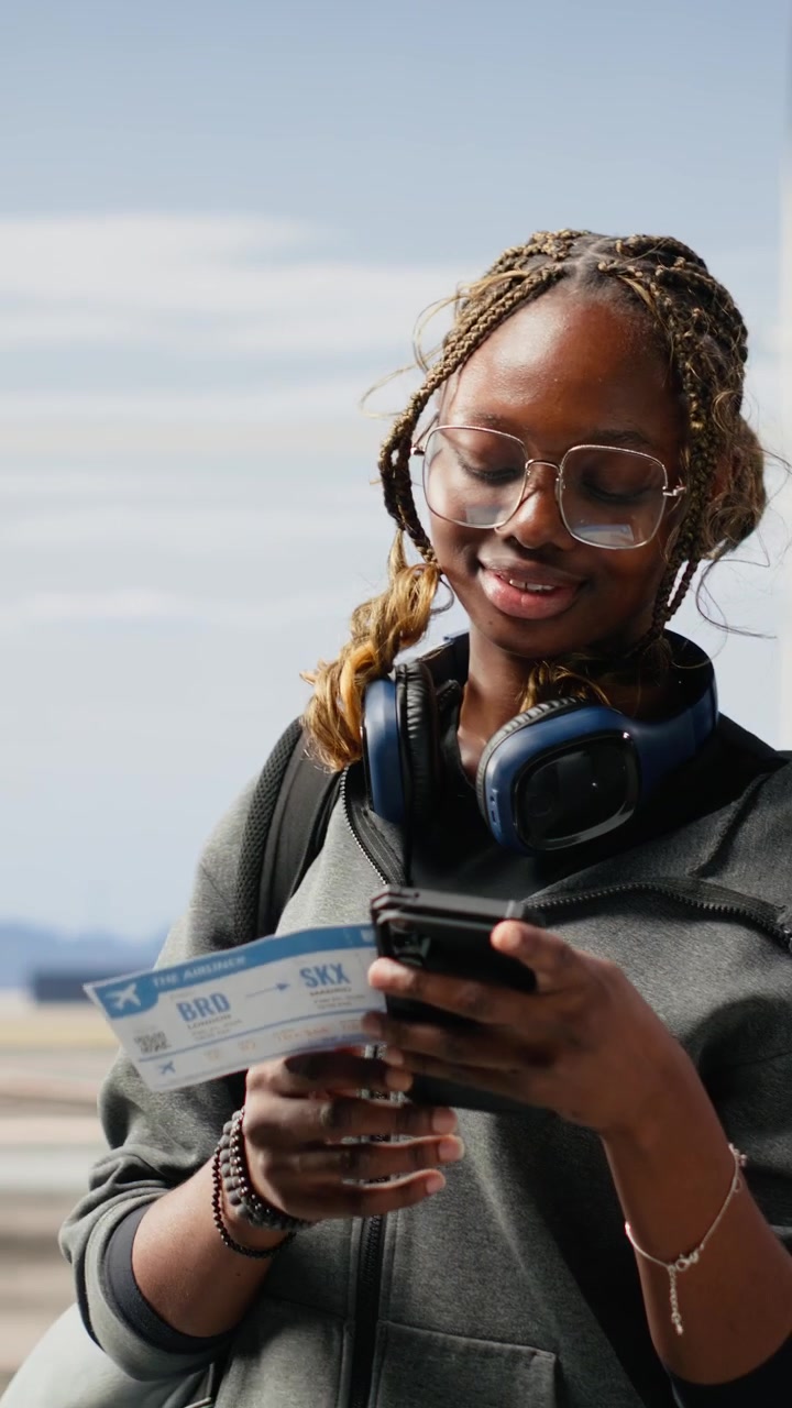 Vertical Video Woman traveler standing alone in modern airport terminal