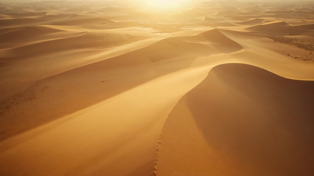 Descending aerial camera moving along dune ridge at sunset, revealing rippled dunes and sun