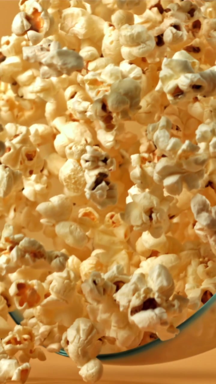Popcorn al rallentatore che cade in una ciotola di vetro