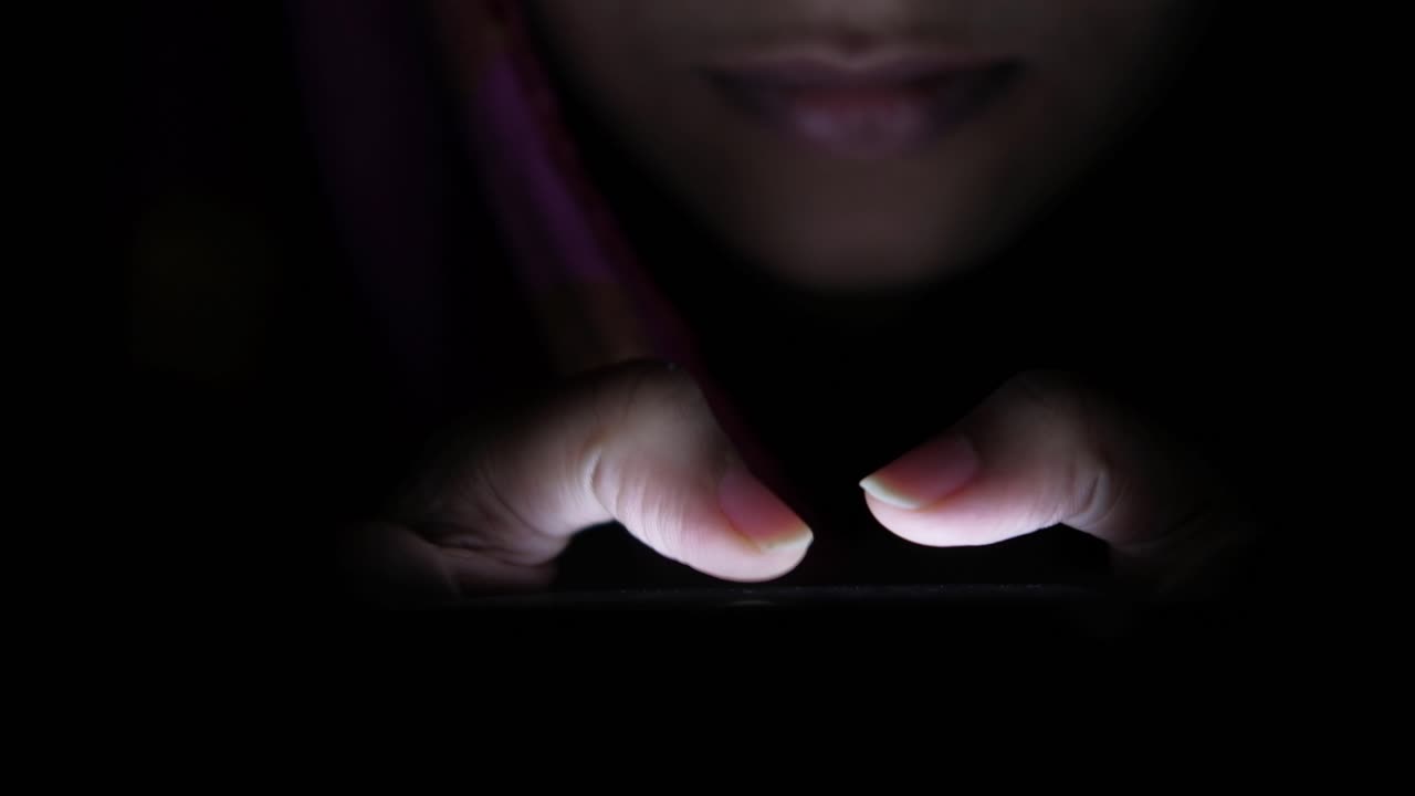 mujer usando teléfono móvil por la noche