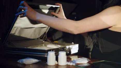 a man and a woman are packing drugs in a suitcase for sale. drug trade. illegal business