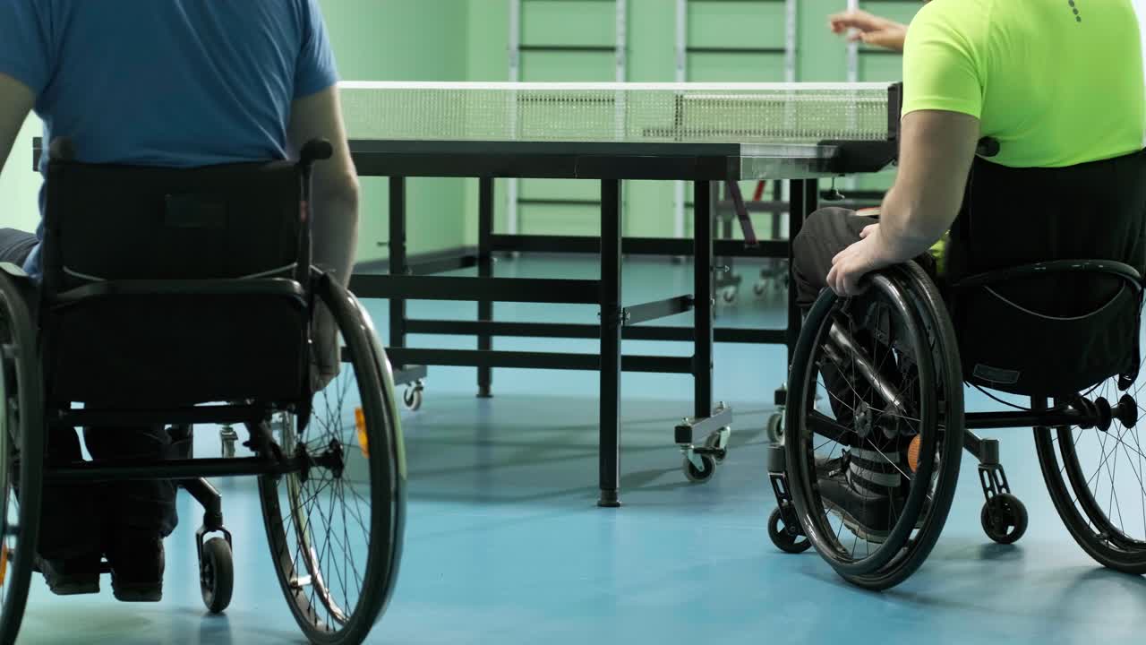 체어에 앉아 있는 남자가 핑핑을 하고, 장애인들이 탁구를 하고, 장애인의 재활, 패럴림픽 스포츠.