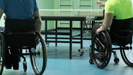 a man in a wheelchair plays ping pong. people with disabilities play table tennis. rehabilitation of the disabled. paralympic sport.