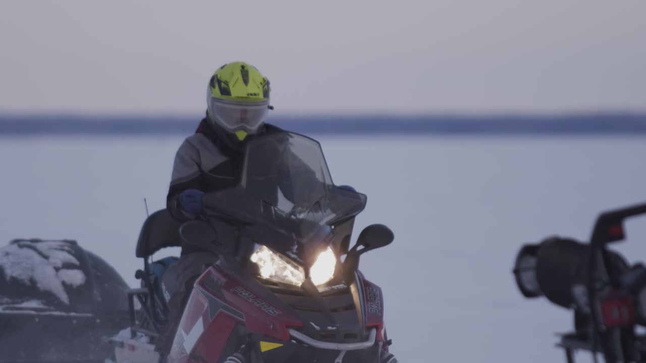 2 motos de nieve conduciendo por un lago congelado