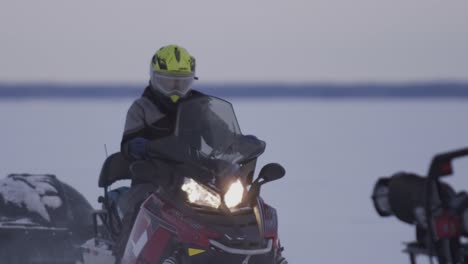 2 snowmobiles driving across a frozen lake