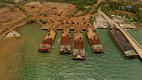 aerial drone shot showing ships or barges collecting material from nickel mines in taganito, philippines