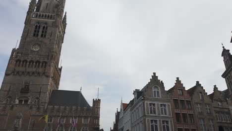 historic european square with medieval architecture and cloudy sky in bruges belgium