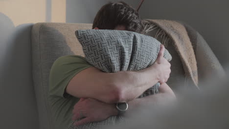 hombre abrazando su almohada en casa. concepto de confort