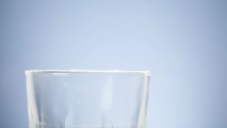 pouring milk into glass. white milk filling up clear glass. milk pouring in front of white background