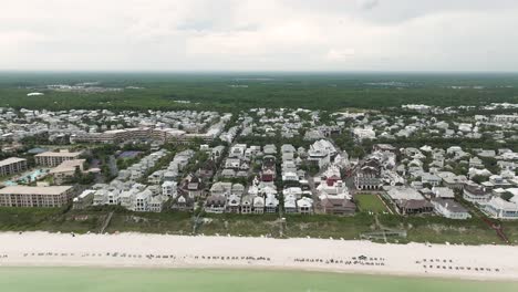 Vista-Amplia-En-Movimiento-Recto-Hacia-Atrás-De-La-Ciudad-De-Rosemary-Beach,-Verde-Occidental-Con-Frente-A-La-Playa-Con-Horizonte-Asky-En-La-Parte-Posterior