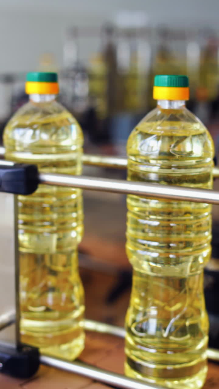 Interior of modern natural oil factory. Bottling the sunflower oil into plastic container Vertical video