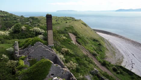 abandonado cubierto de hiedra cubierto desolado campo histórico galés costero fábrica de ladrillos molino vista aérea cerrar órbita derecho