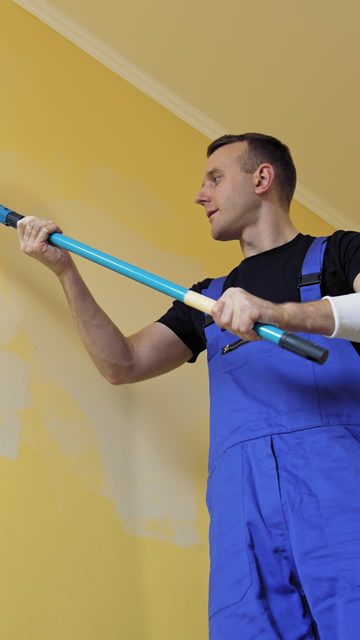 Man doing new room interior with paint. Young handsome male doing renovation. Vertical video