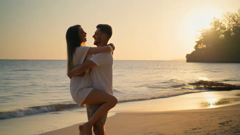 romantic couple embracing on a beach at sunset