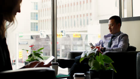 Side-view-of-Asian-businessman-using-mobile-phone-in-a-hotel-lobby-4k