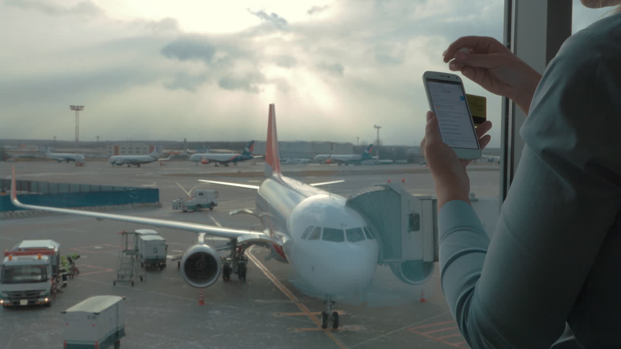 en el aeropuerto vista de una mujer haciendo pago con tarjeta bancaria usando teléfono inteligente y dongle para escanear tarjeta bancaria