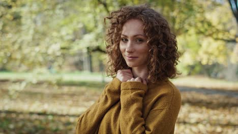 retrato de una mujer caucásica de pie en el parque durante el otoño.