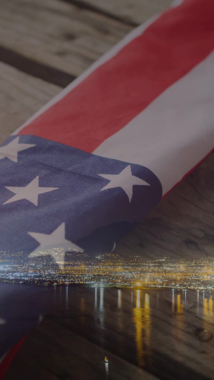 Video verticale: Inquadratura ravvicinata con panoramica iniziale che rivela una bandiera americana piegata e uno skyline in onore dei veterani.