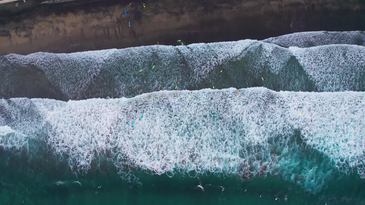 Top down aerial view of surfers riding waves at Las Canteras Beach , Canary Islands, Europe