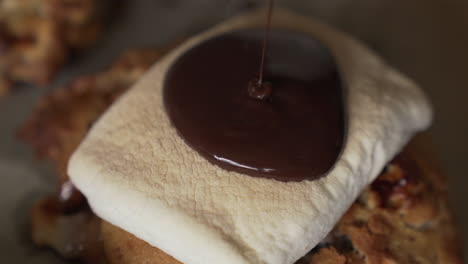 dripping chocolate syrup on top of marshmallow cookie