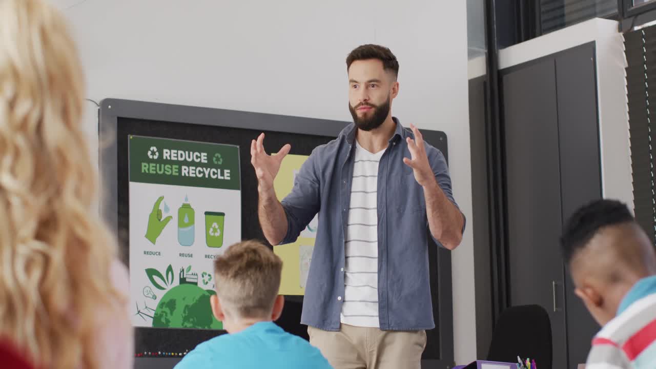 maestro masculino diverso y escolares felices en el escritorio en el aula de la escuela