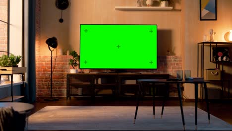 stylish loft apartment interior with tv set with green screen mock up display standing on television stand. empty living room at home with chroma key placeholder on monitor. zoom in sunset warm shot.