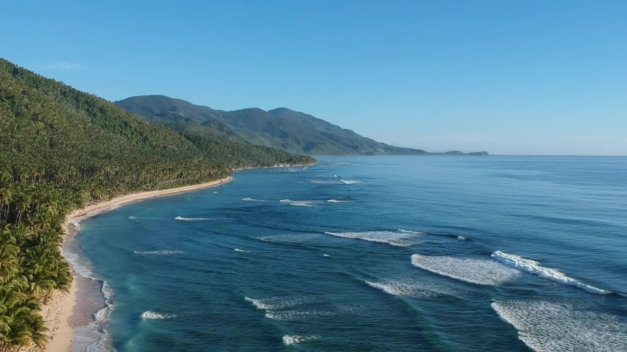 Drone che si allontana delicatamente per rivelare una splendida montagna, una spiaggia di sabbia bianca e le onde dell'oceano
