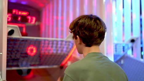 kid playing an arcade basketball game