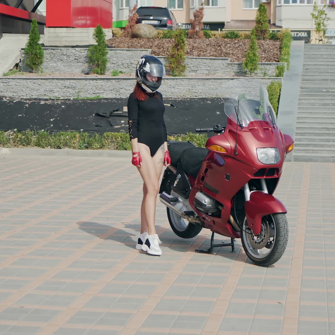 . Female biker on motorbike. Young pretty woman sitting on motorbike