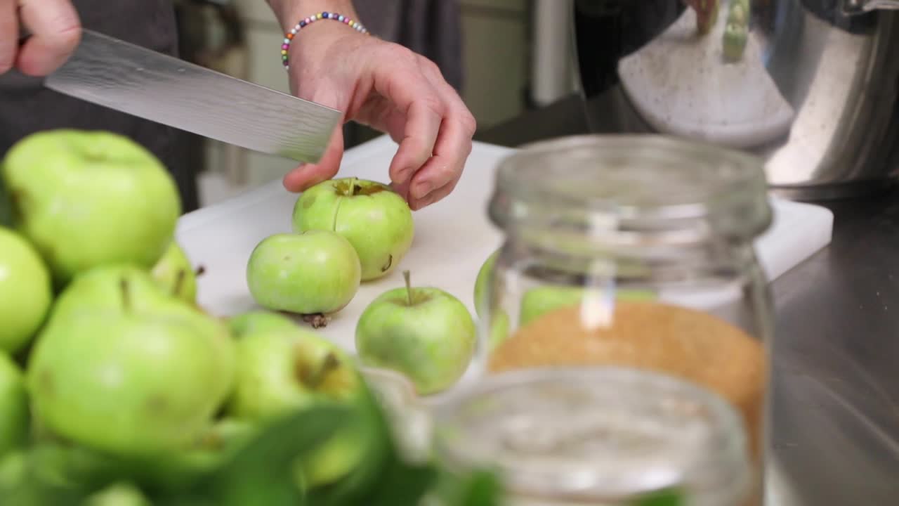 chef mujer cortando manzanas verdes frescas en la cocina - cierre, cámara lenta