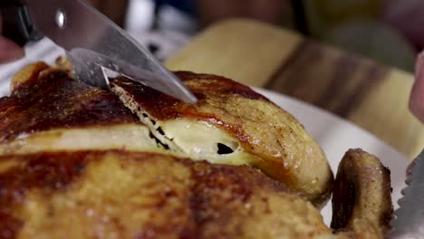 close up of full chicken being cut in half with scissors