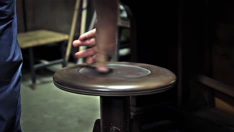 old man adjusting an old piano stool. close up. 4k resolution.