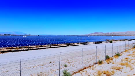 granja solar fotovoltaica vuelo aéreo de drones bajos y elevación sobre una gran variedad de paneles en el desierto de sonora, 4k