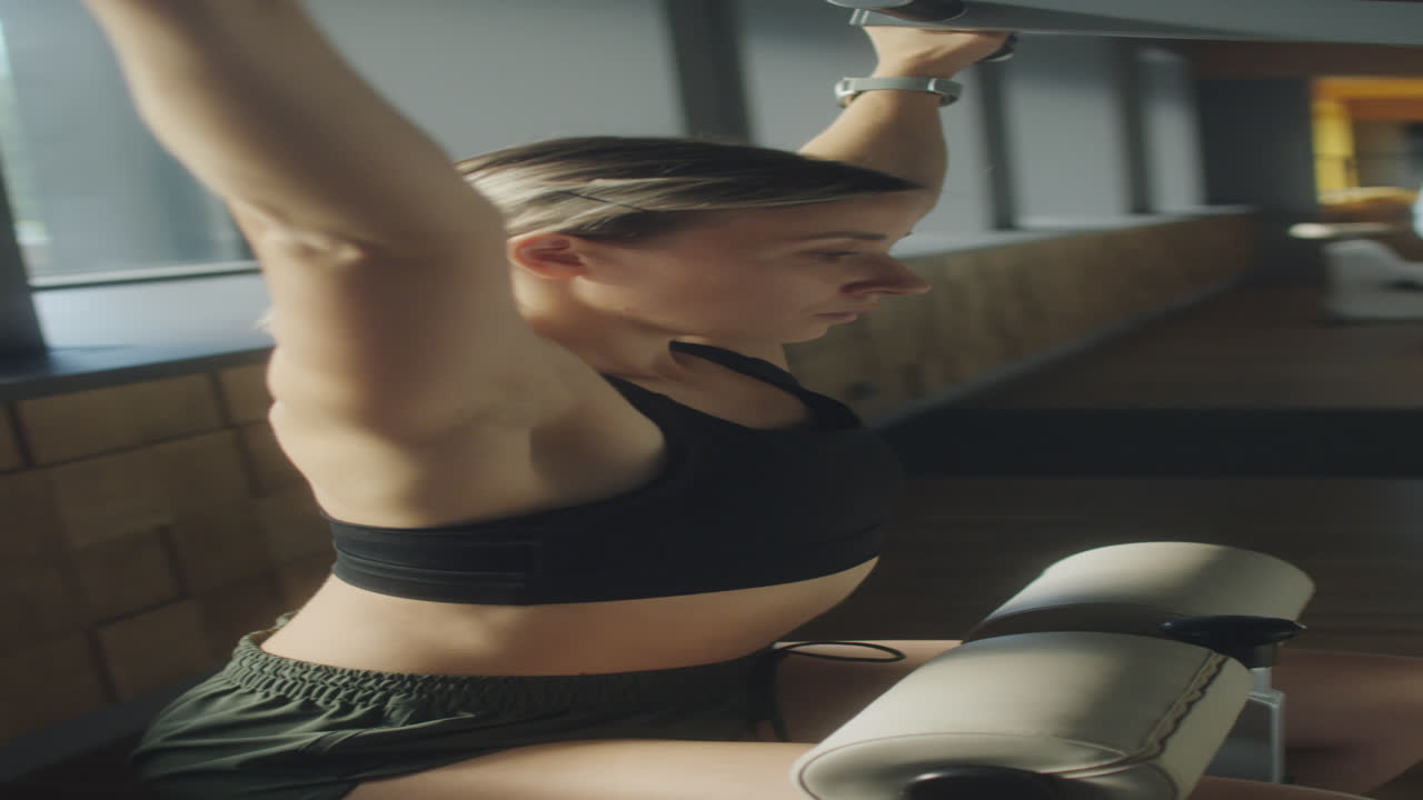 Woman Training with Lat Pulldown Machine in Gym