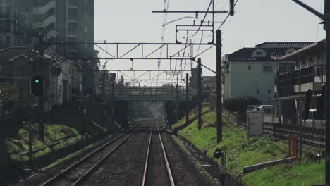 rear view inside a moving train on the track in tokyo, japan - pov - timelapse