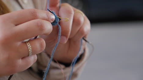 close-up of hands knitting with soft-focus background