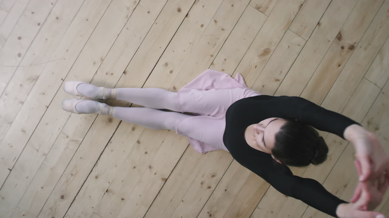 Top View Of Ballerina Sitting On Wooden Floor