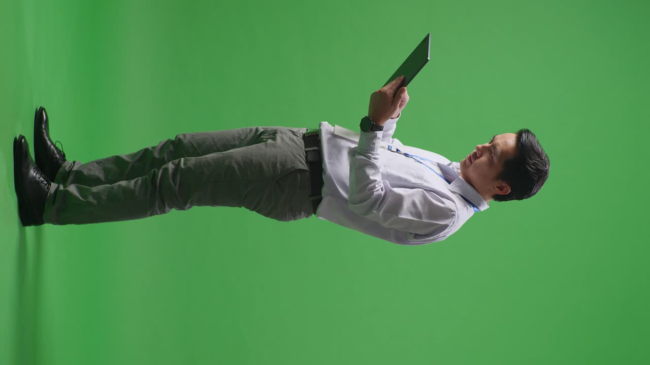 녹색 화면에 태블릿을 들고 있는 사업가