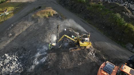 aérea de trabajadores de la construcción perforando agujeros en el suelo preparándose para volar rocas