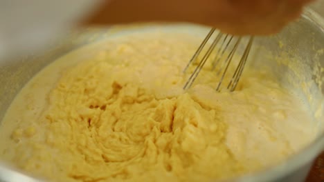 making mashed cassava in a large bowl and stirring with a whisk - ingredients harvested on organic farms in the amazon rainforest