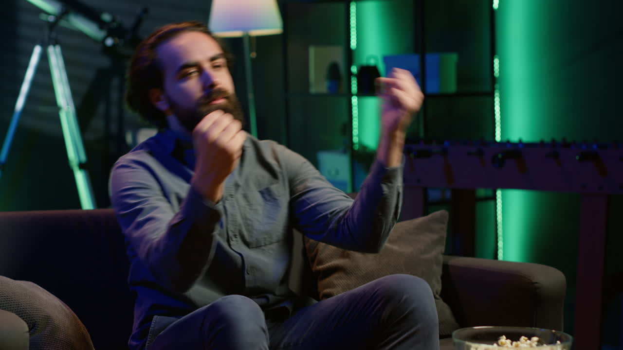 hombre deprimido en casa en el sofá viendo un partido deportivo en vivo