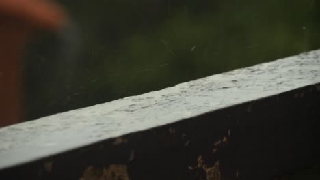 Pequeñas-Gotas-De-Agua-De-Lluvia-Cayendo-En-Un-Chapoteo-En-Una-Vieja-Pared-De-Balcón-Con-Pintura-Vieja-Durante-Un-Día-Nublado-En-El-Sur-De-Francia,-Cerca-De-Marsella