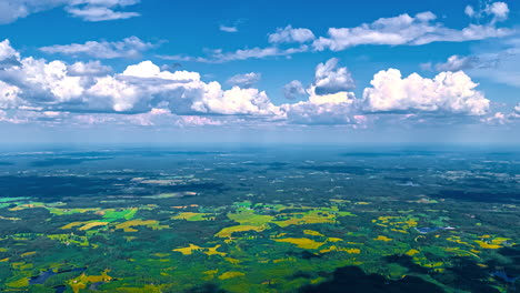 shadows from clouds crossing rural farms and forests in europe's fertile, summer landscape - high altitude aerial time lapse