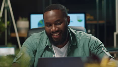 closeup smiling african businessman drinking coffee in night office