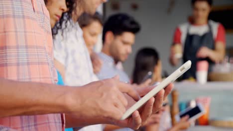 Freunde-Nutzen-Mobiltelefon-Und-Digitales-Tablet-Am-Schalter