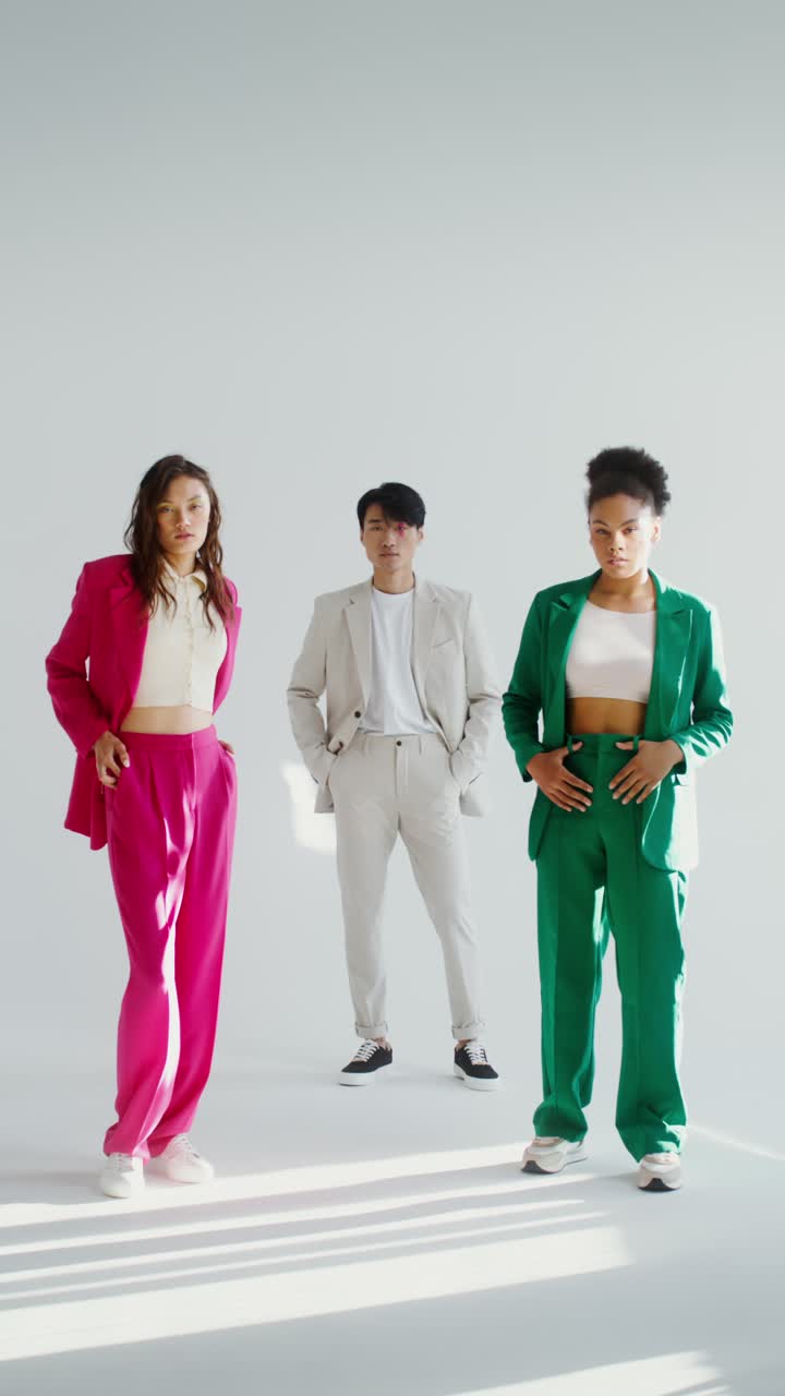 Fashionable people in suits posing in a studio